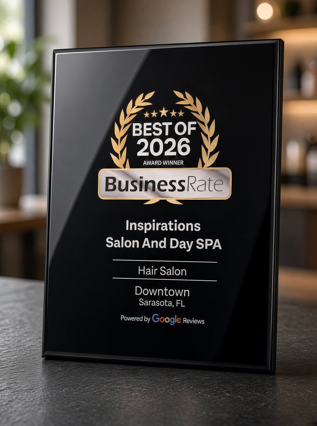 Framed award plaque on a table reading Best of 2026, BusinessRate, Inspirations Salon And Day SPA, Hair Salon, Downtown Sarasota, Florida, powered by Google Reviews.
